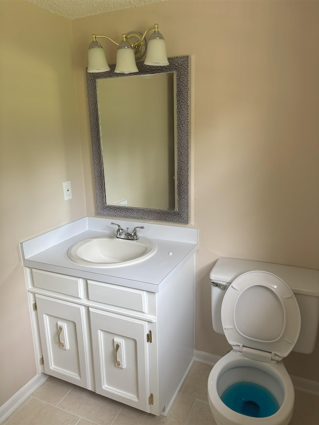 bathroom featuring tile patterned floors, vanity, toilet, and baseboards