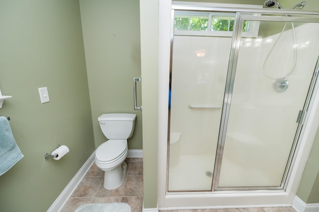 bathroom with a shower stall, baseboards, toilet, and tile patterned floors