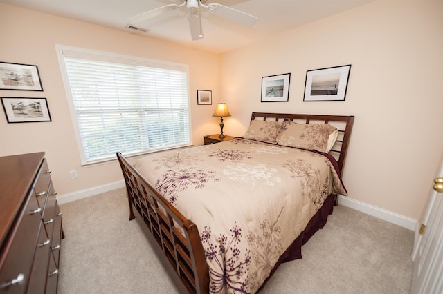 bedroom featuring light colored carpet, baseboards, and a ceiling fan