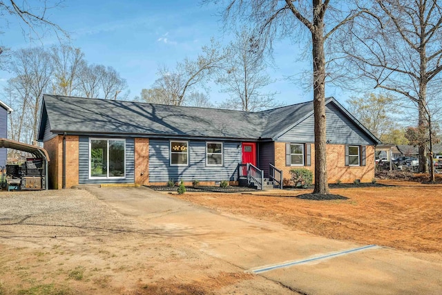 2 Willowood, Spartanburg, SC 29303 - view of front of home with brick siding, a carport, dirt driveway, and a shingled roof