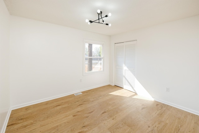 2 Willowood, Spartanburg, SC 29303 - unfurnished bedroom featuring a chandelier, light wood-type flooring, a closet, and baseboards
