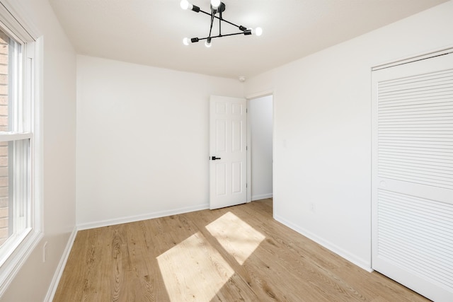 2 Willowood, Spartanburg, SC 29303 - unfurnished bedroom with light wood-type flooring, a chandelier, baseboards, and a closet