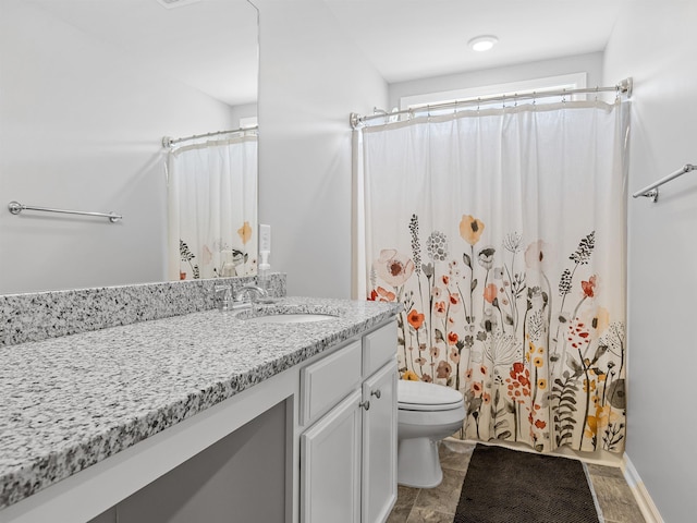bathroom featuring toilet, vanity, and a shower with curtain