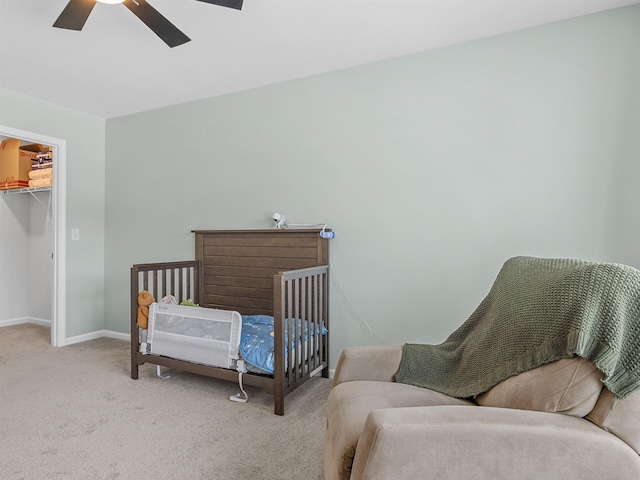 carpeted bedroom with a spacious closet, baseboards, ceiling fan, and a closet