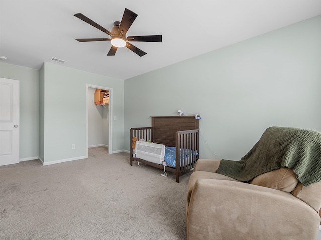 bedroom featuring carpet, a walk in closet, baseboards, a ceiling fan, and a closet