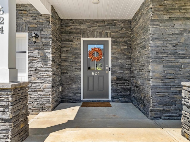 property entrance with stone siding and covered porch