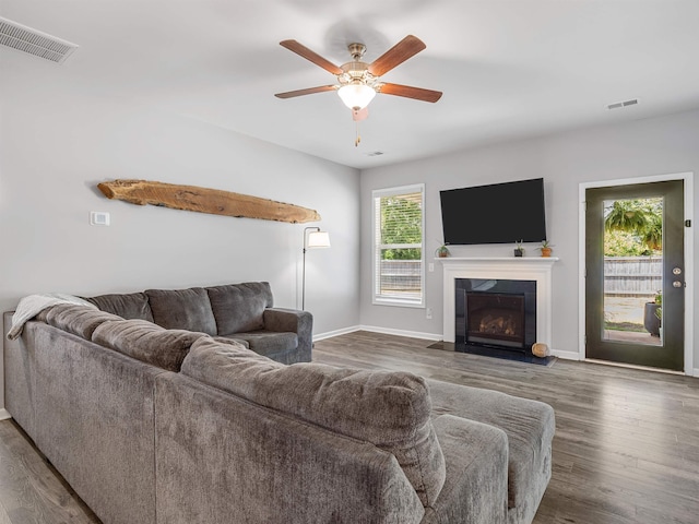living area featuring ceiling fan, wood finished floors, and baseboards