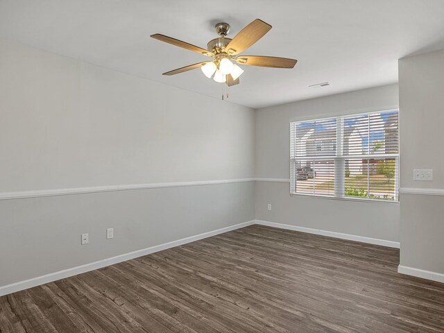 empty room featuring dark wood-style flooring, baseboards, and ceiling fan