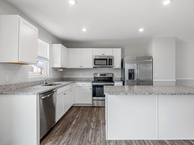 kitchen with stainless steel appliances, a sink, white cabinetry, dark wood-type flooring, and recessed lighting