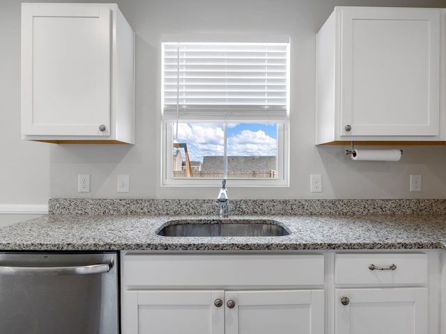 kitchen featuring dishwasher, a sink, white cabinetry, and light stone counters
