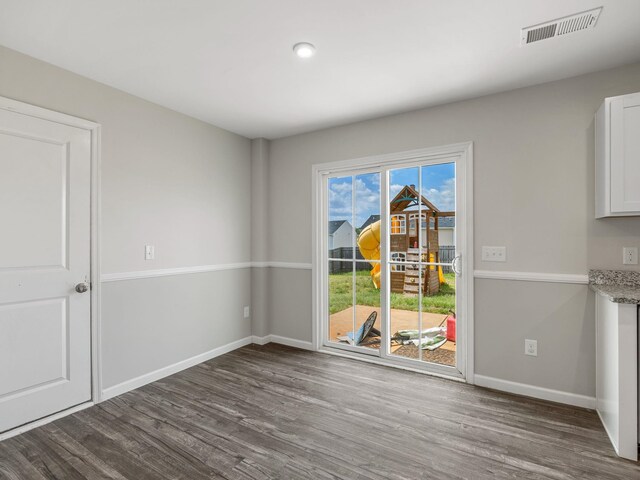 unfurnished dining area featuring wood finished floors and baseboards