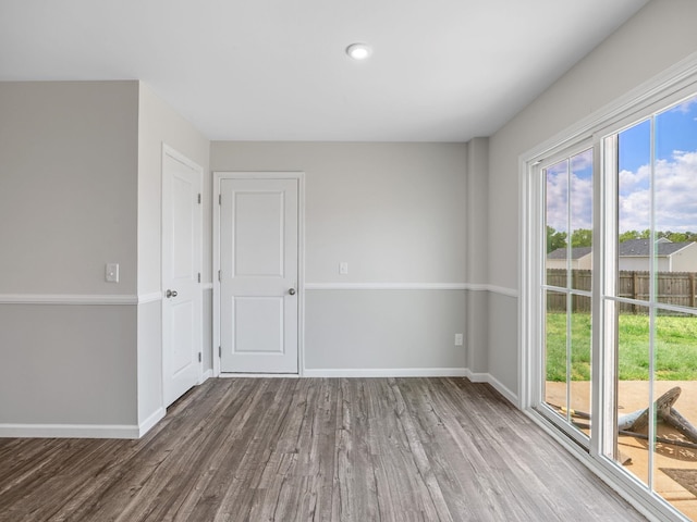 unfurnished room featuring wood finished floors and baseboards