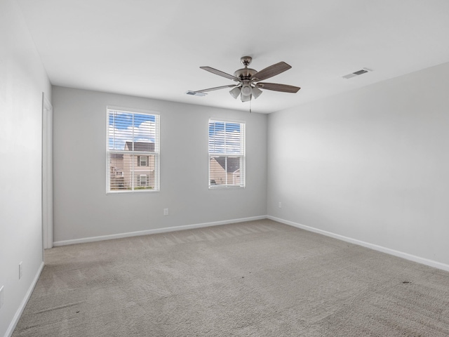carpeted empty room featuring a ceiling fan and baseboards
