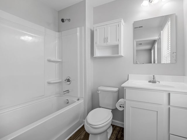bathroom with toilet, wood finished floors, vanity, tub / shower combination, and baseboards