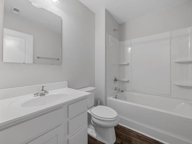 full bathroom featuring wood finished floors, toilet, vanity, and shower / tub combination