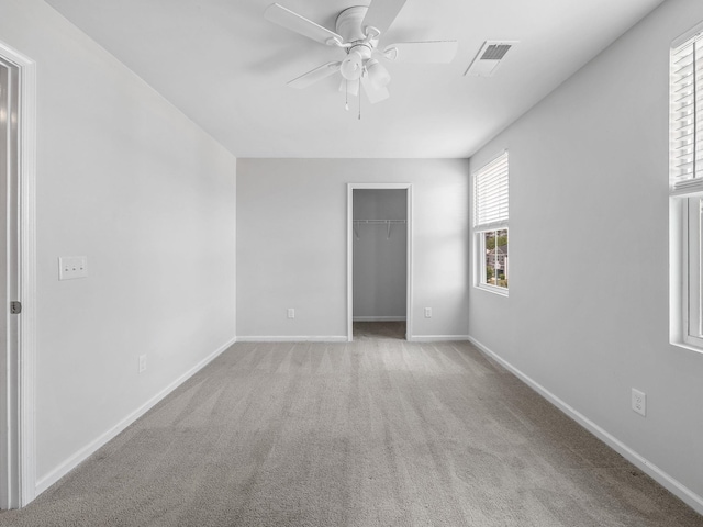 carpeted spare room featuring a ceiling fan and baseboards