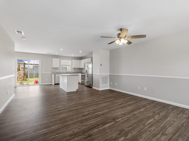 unfurnished living room featuring dark wood-type flooring, baseboards, ceiling fan, and recessed lighting