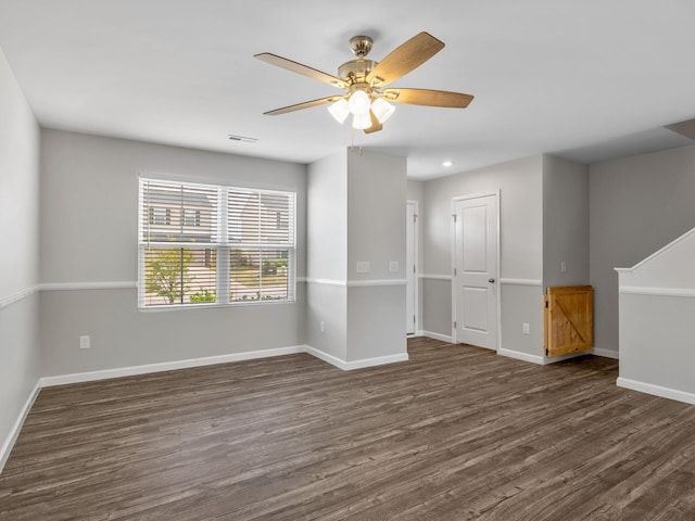 unfurnished room featuring dark wood finished floors, baseboards, and ceiling fan