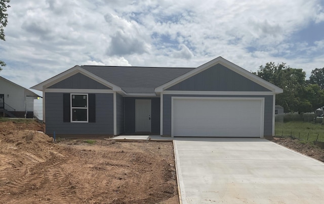 ranch-style house featuring driveway, an attached garage, and board and batten siding