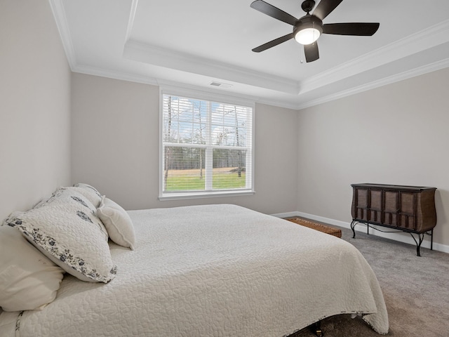 carpeted bedroom featuring a raised ceiling, crown molding, baseboards, and ceiling fan