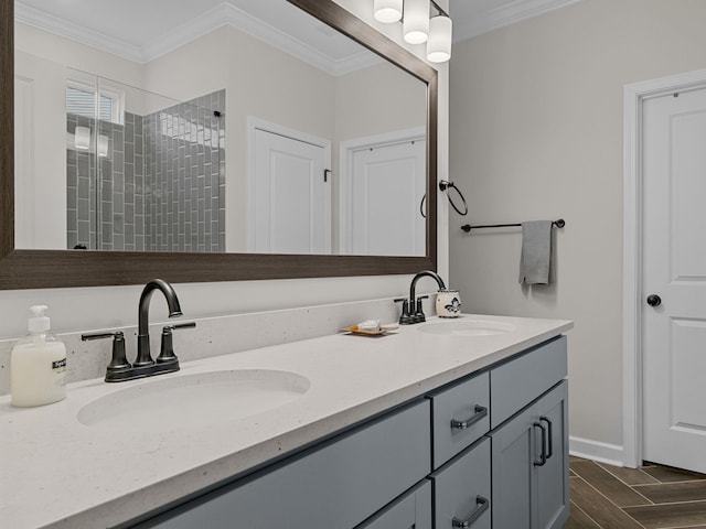 bathroom featuring double vanity, wood finished floors, crown molding, and a tile shower