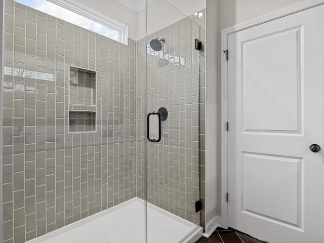bathroom with a shower stall and crown molding