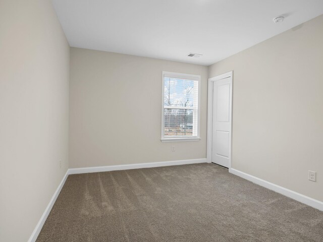 carpeted spare room featuring baseboards