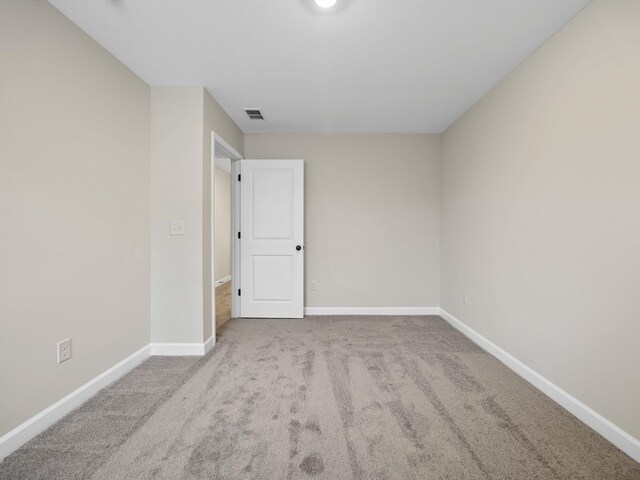 spare room with baseboards and carpet