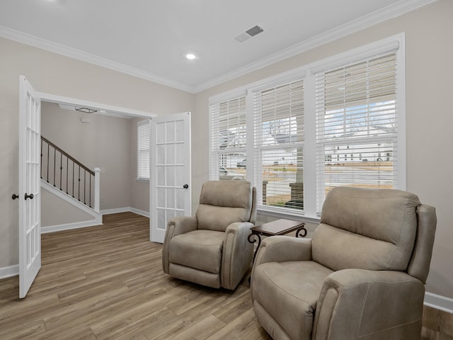 living area with french doors, light wood-style floors, ornamental molding, baseboards, and recessed lighting