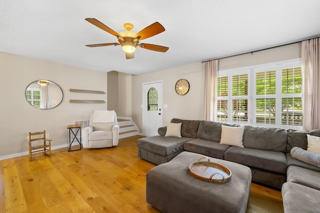 living room featuring light wood-style floors, ceiling fan, and baseboards