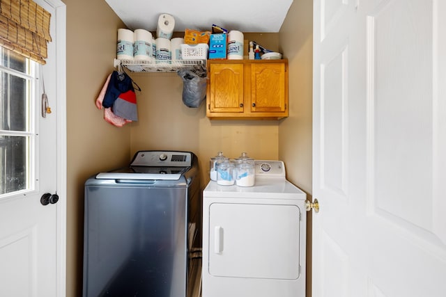washroom featuring washing machine and clothes dryer and cabinet space