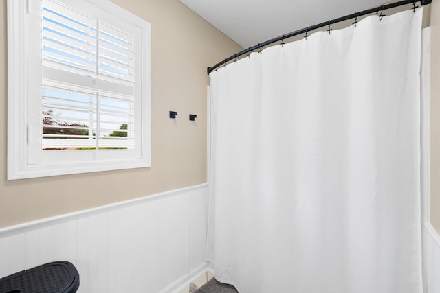 full bathroom featuring a wainscoted wall