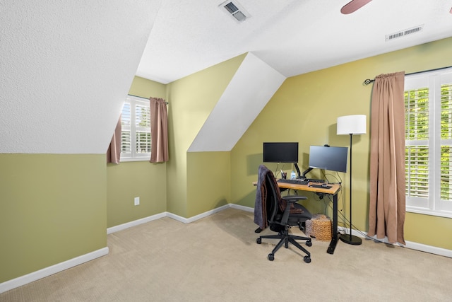 carpeted home office with healthy amount of natural light, baseboards, vaulted ceiling, and ceiling fan