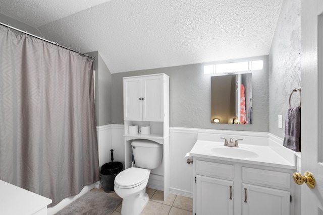 full bath featuring a textured ceiling, vanity, toilet, tile patterned floors, and lofted ceiling