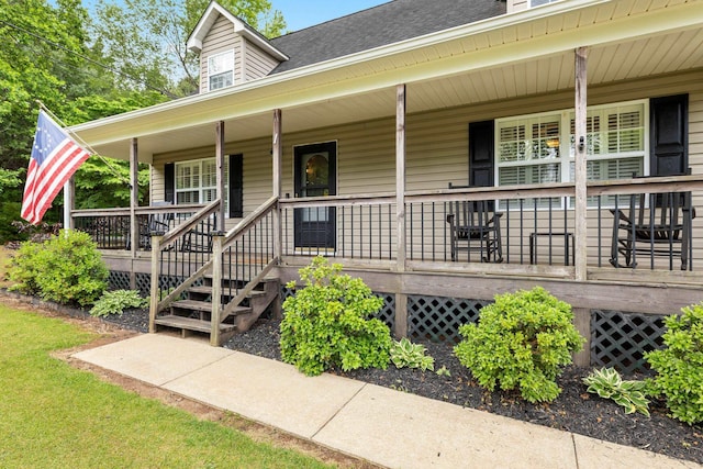doorway to property featuring covered porch and a shingled roof