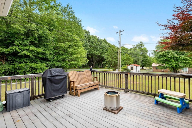 wooden deck with area for grilling and a lawn