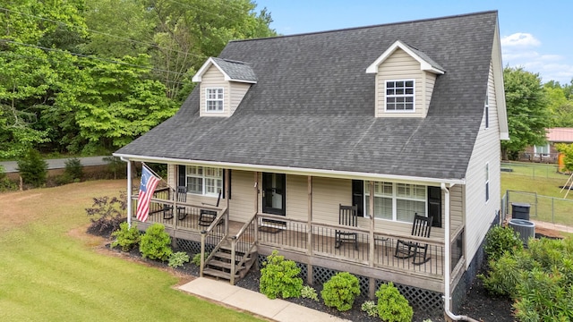 view of front of property featuring central AC unit, roof with shingles, and covered porch