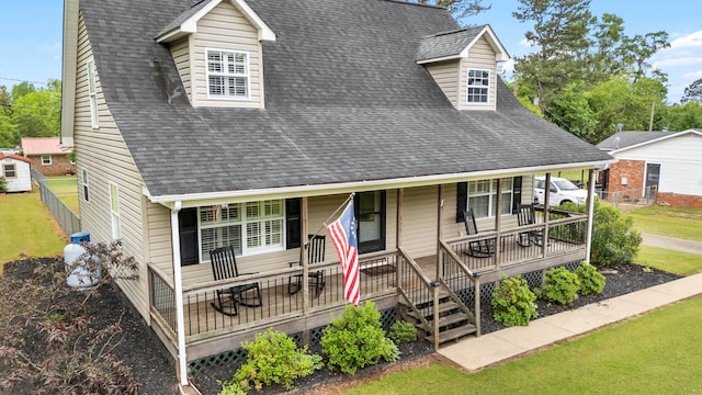 view of front facade with roof with shingles and a front yard