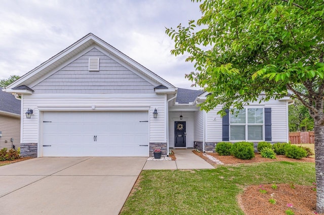 view of front of property with stone siding, driveway, an attached garage, and fence