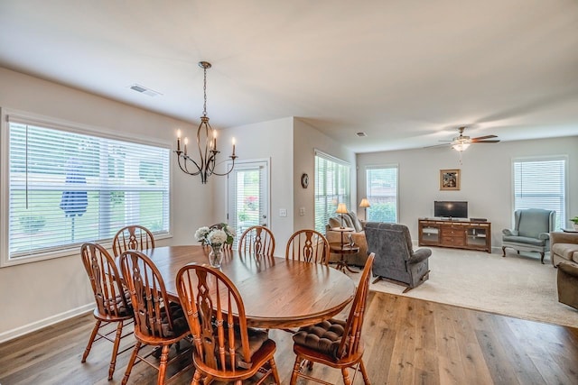 dining area with a chandelier, wood finished floors, baseboards, and ceiling fan