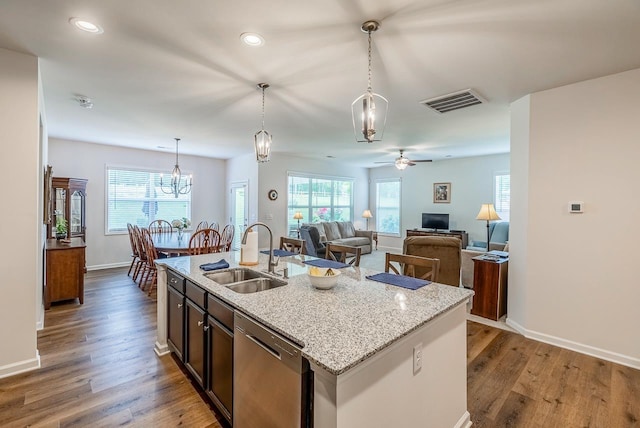 kitchen with a sink, dishwasher, wood finished floors, plenty of natural light, and recessed lighting