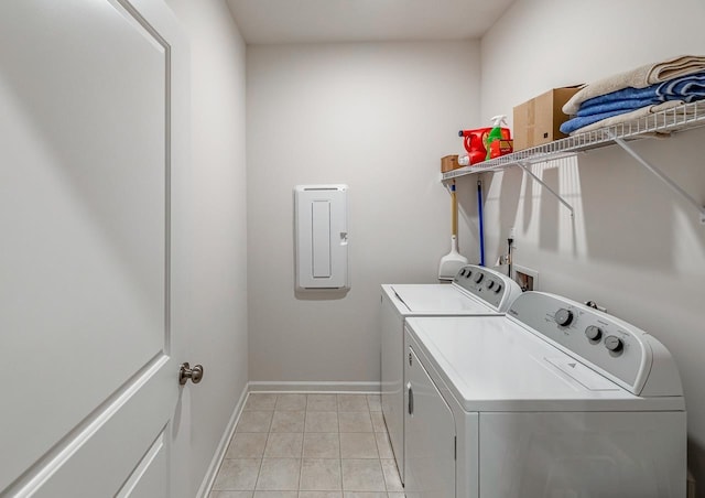 washroom with washing machine and clothes dryer, baseboards, and light tile patterned floors