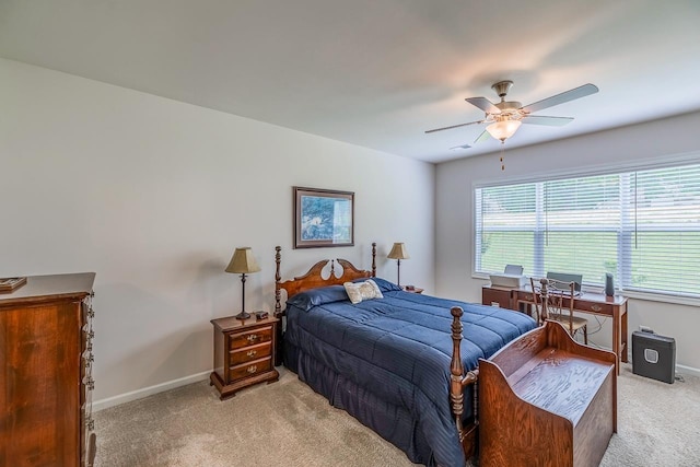 bedroom featuring light colored carpet, baseboards, and a ceiling fan