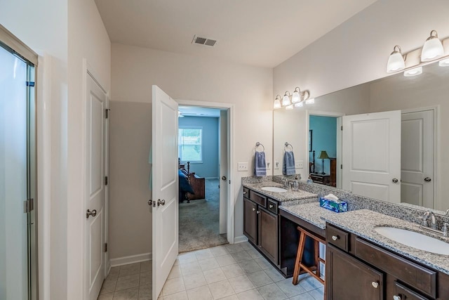 bathroom with double vanity, baseboards, and tile patterned floors