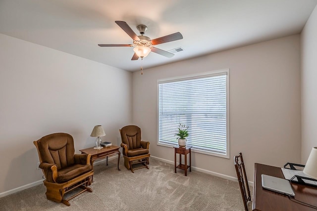 sitting room featuring a ceiling fan, baseboards, and light colored carpet