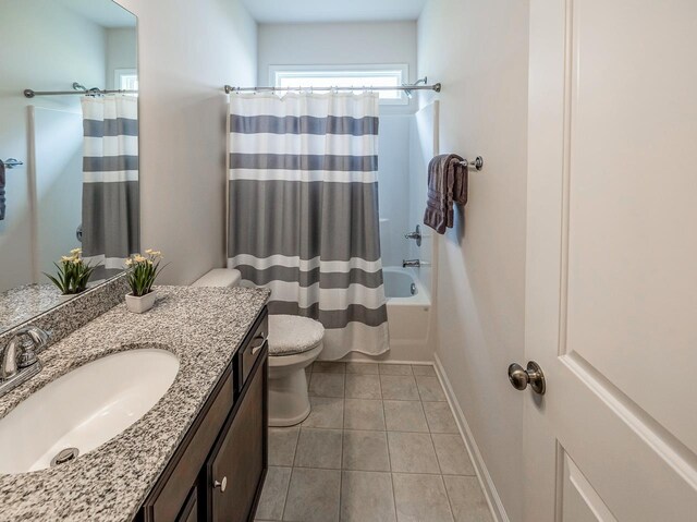 bathroom with toilet, tile patterned flooring, vanity, shower / tub combo with curtain, and baseboards