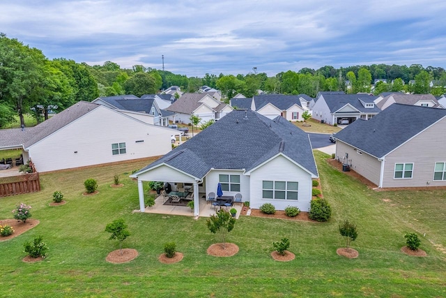 rear view of property with a patio area, roof with shingles, a residential view, and a lawn