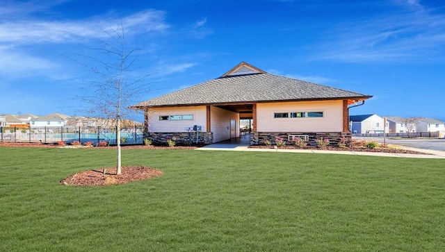 back of property with a shingled roof and a residential view