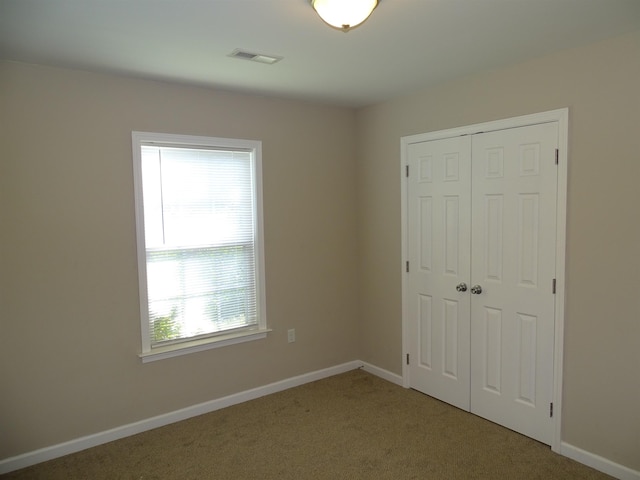 unfurnished bedroom with a closet, carpet flooring, and baseboards