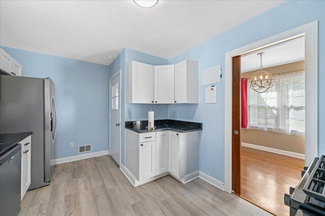 222 Woodview, Spartanburg, SC 29306 - kitchen with appliances with stainless steel finishes, light wood-type flooring, a chandelier, white cabinets, and baseboards